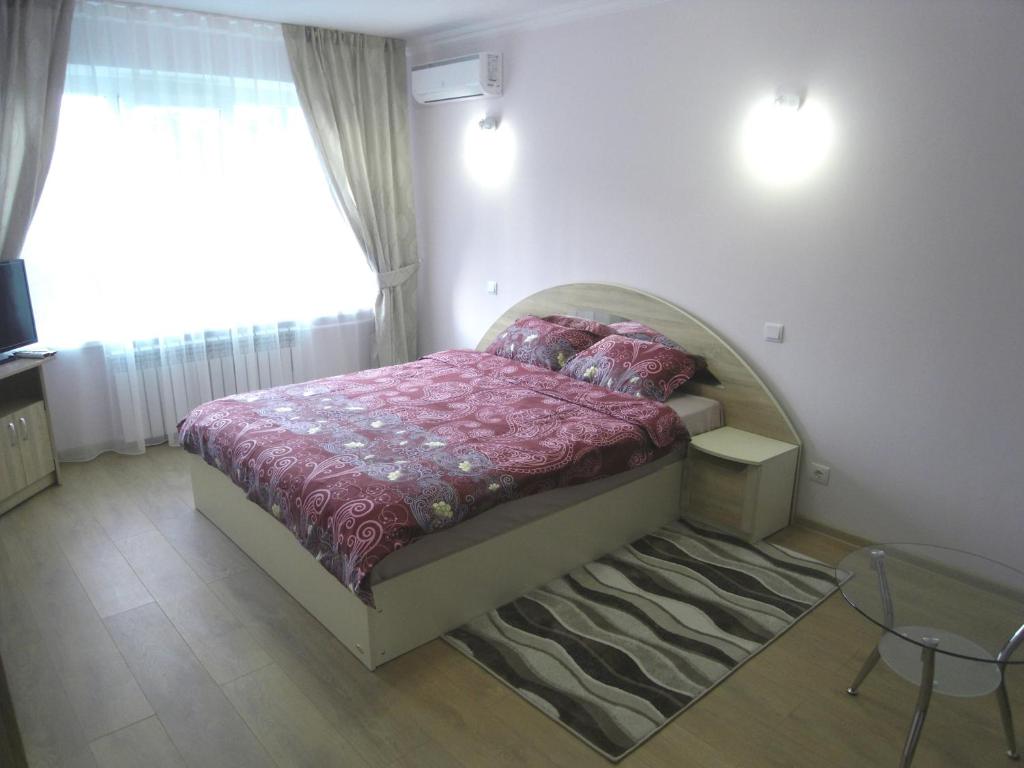 基希讷乌现代公寓的一间卧室配有一张床、一张桌子和一个窗户。
