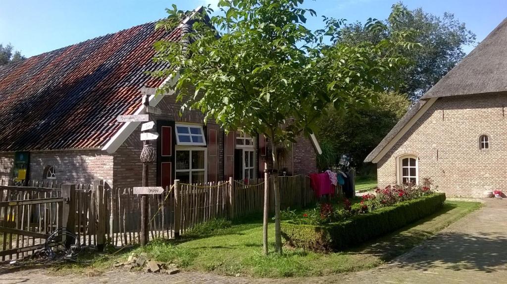 Wijhelandgoed Groot Boerle的一座带栅栏和树的老房子