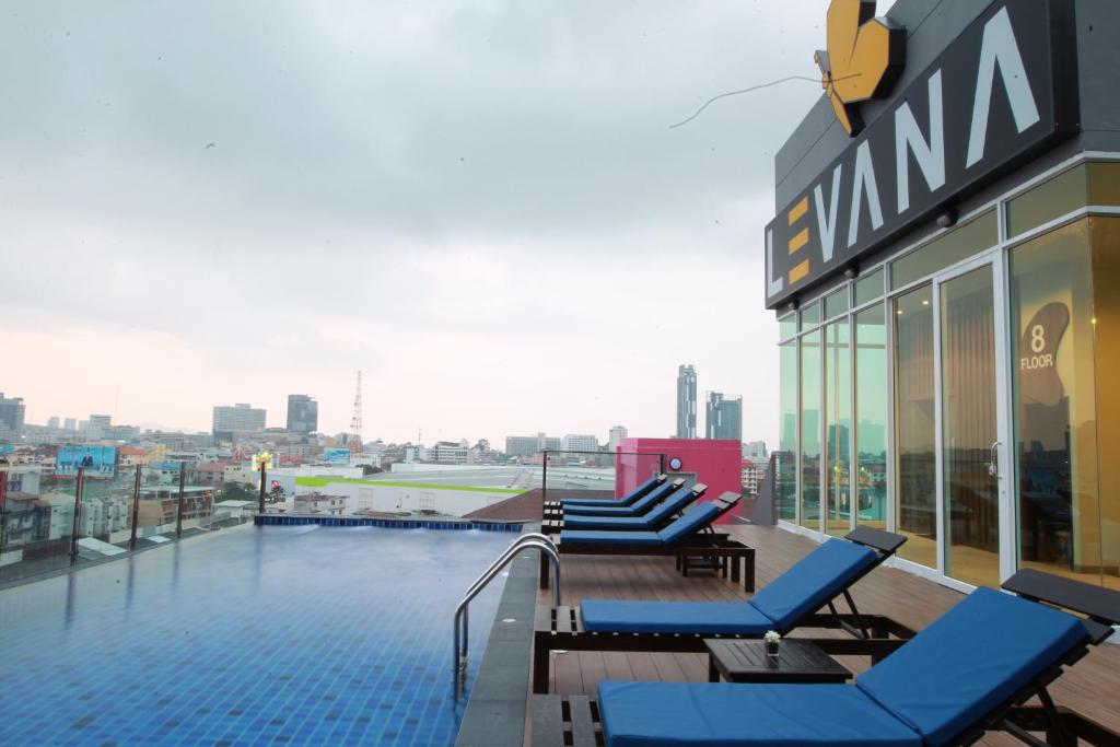芭堤雅市中心Levana Pattaya Hotel - SHA Extra Plus的一座带躺椅的建筑屋顶上的游泳池