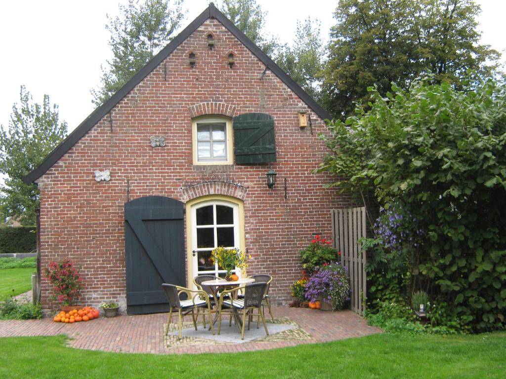 LiempdeDe Hopbel & Het Koevinkje的院子里的砖屋,配有桌椅