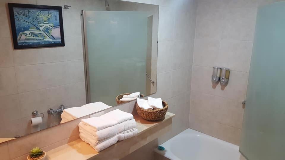 布宜诺斯艾利斯Dg Apart Obelisco的浴室设有镜子和毛巾,位于柜台上