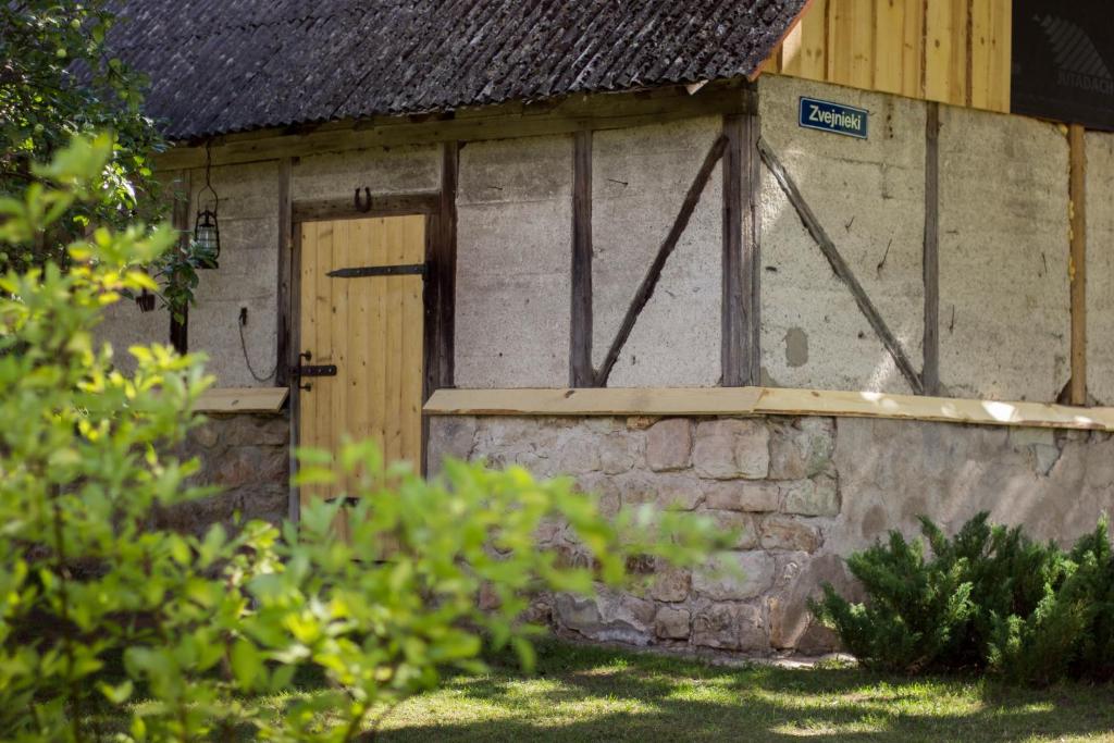 ĶegumsLauku māja "Zvejnieki"的一座带木门和石墙的建筑