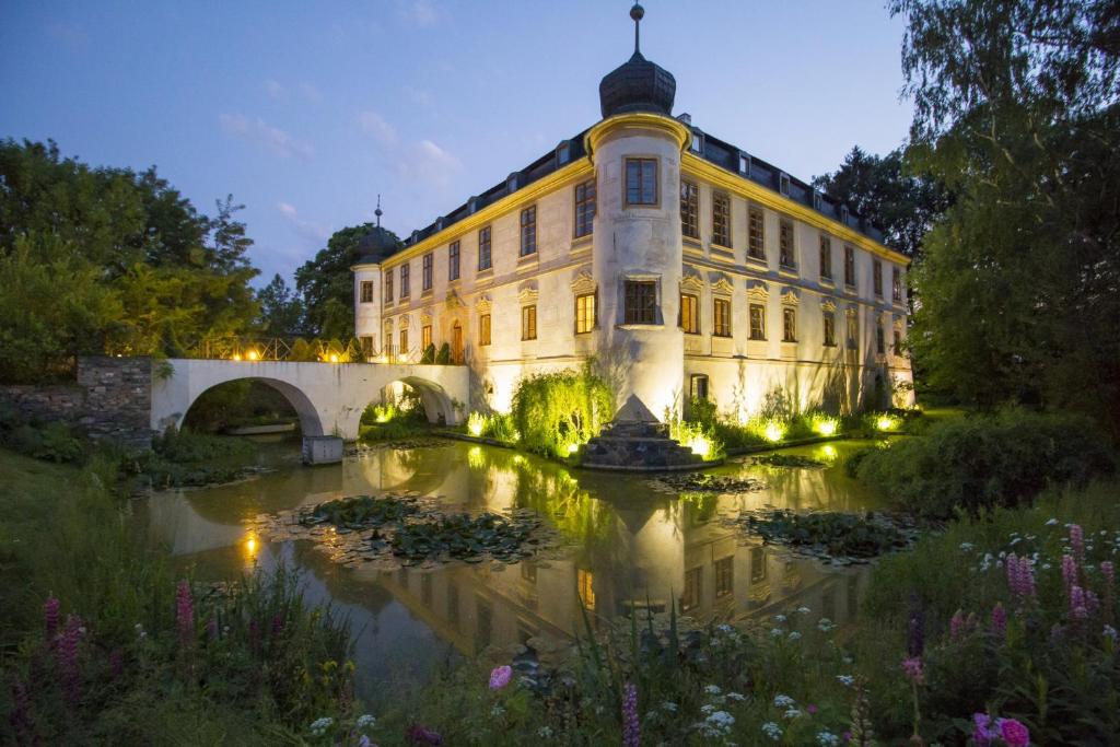 库特纳霍拉特博西兹城堡酒店的一座大建筑,前面有一个池塘