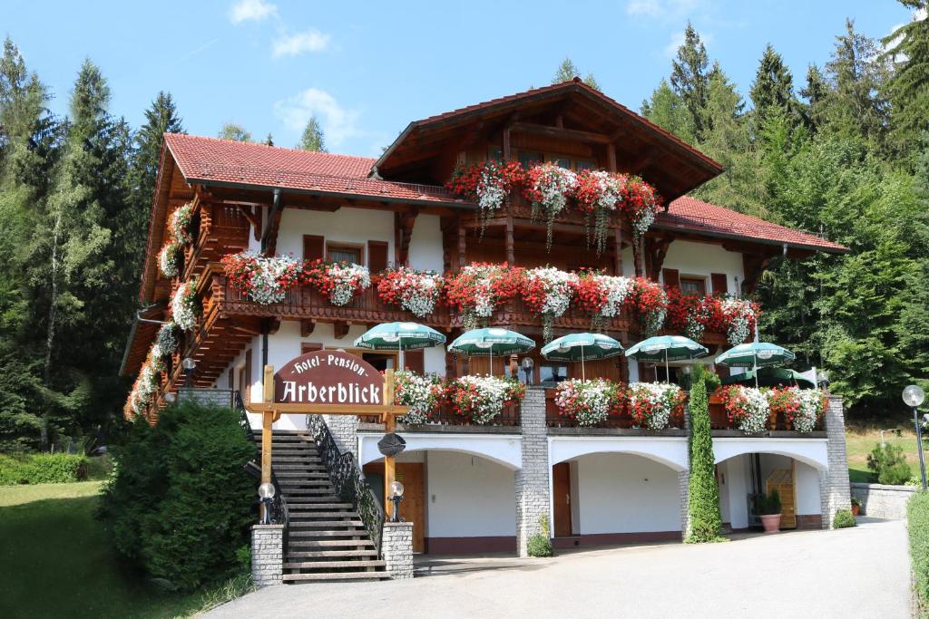 洛贝格GarniHotel - Arberblick的一座花朵和雨伞的建筑