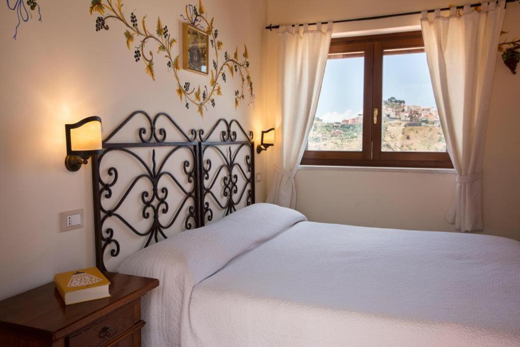 陶尔米纳迪卡特里纳乡村民宿的卧室配有白色的床和窗户。