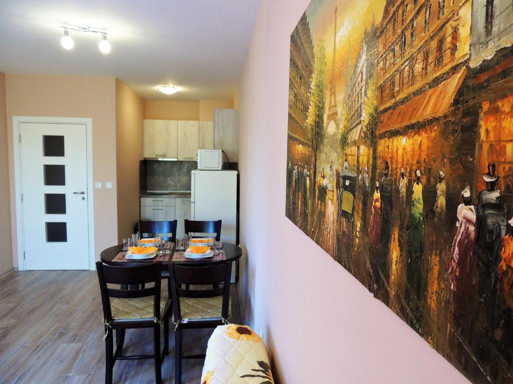 希萨里亚Хисаря ВИП апартаменти的厨房配有桌子,墙上挂着一幅大画