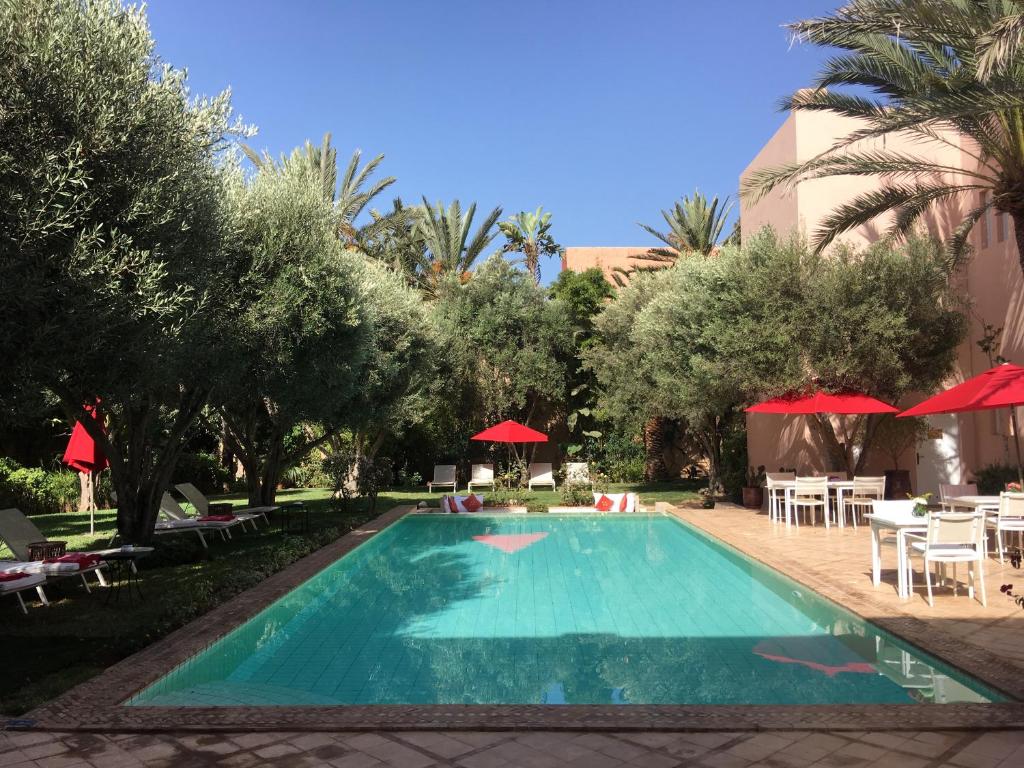 阿加迪尔里亚德斯高尔夫球酒店的一个带遮阳伞和桌椅的游泳池