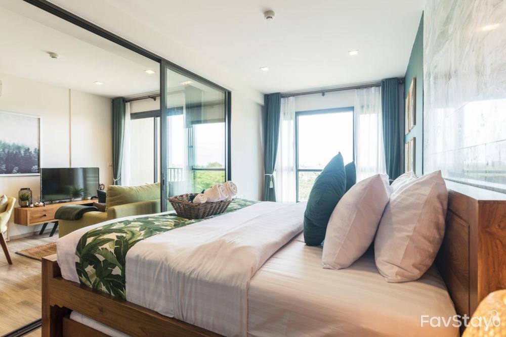 佛丕Rain Cha-am Huahin Tropical style的一间卧室设有一张大床和大窗户
