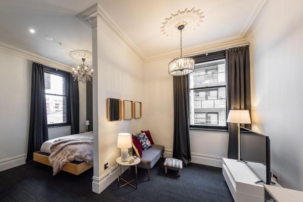 墨尔本东不伦瑞克酒店的一间卧室配有一张床、一把椅子和窗户。