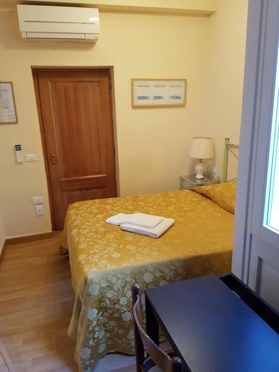 佛罗伦萨伯圣塔玛丽亚酒店的客房设有两张床、一张桌子和一扇窗户。