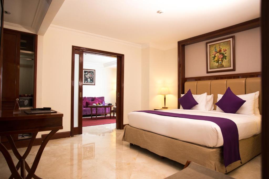 雅加达Arion Suites Hotel Kemang的一间卧室配有一张大床和一张书桌