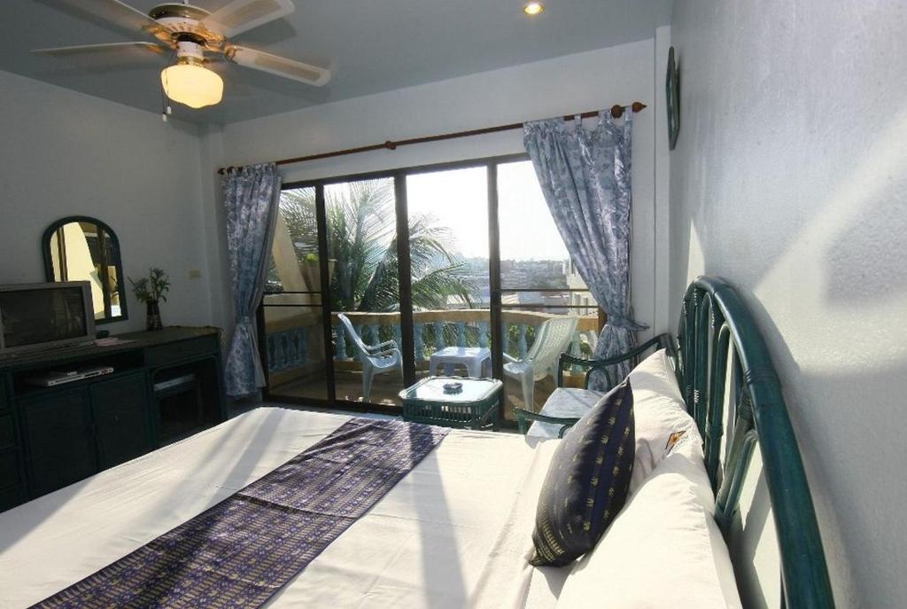 芭东海滩Patong Sunbeach Mansion的一间卧室设有一张床和一个大窗户