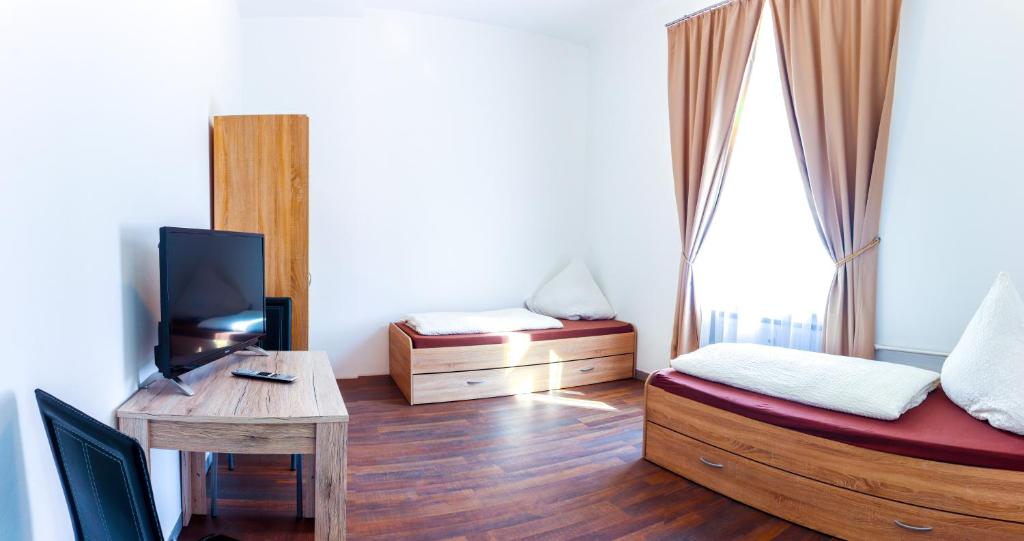 梅明根FMM Hostel的客房设有两张床和一张书桌及一台电视。