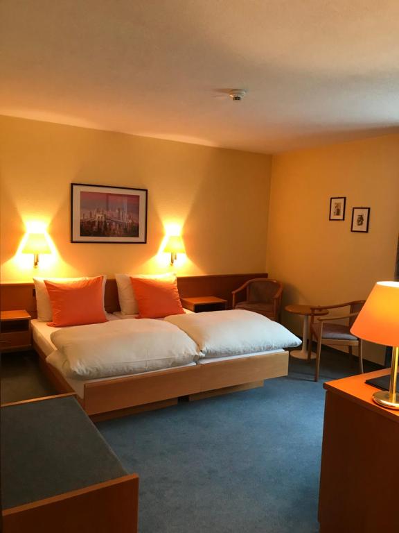 欧博比皮Hotel Eintracht的配有橙色枕头的床的酒店客房
