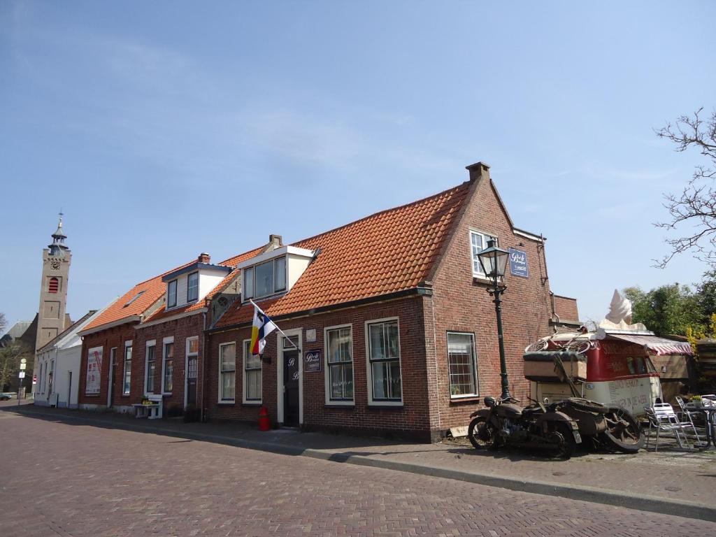 巴勒哈姆斯泰德t拉格Uus住宿加早餐旅馆的一座砖砌建筑,前面有一条船