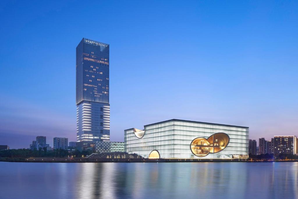 嘉定上海嘉定凯悦酒店的一座大建筑,上面有标志,靠近一个城市