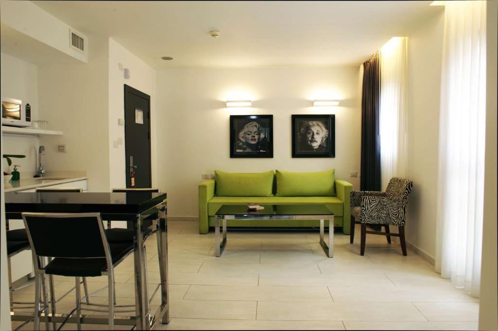 特拉维夫贝斯特韦斯特丽晶套房酒店的客厅配有绿色沙发和桌子