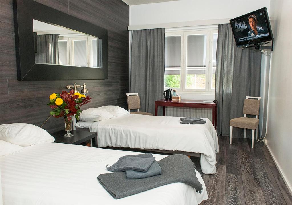 Raisio马汀霍维餐厅酒店的酒店客房设有两张床和电视。