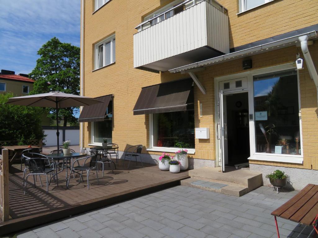 FinspångAlléhotellet的庭院配有桌椅和遮阳伞。