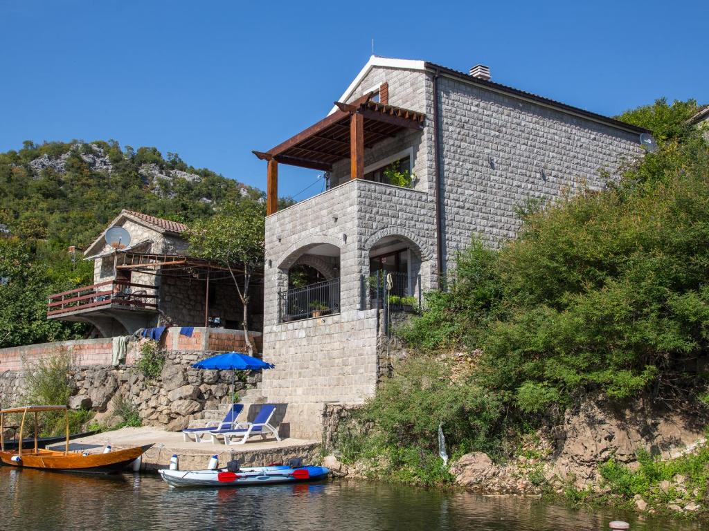 KaručParadise House Skadar Lake的河岸边的房屋,有船