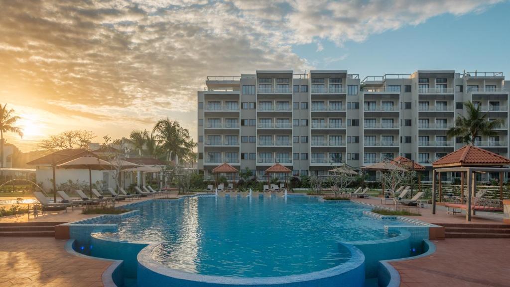 桑给巴尔Hotel Verde Zanzibar - Azam Luxury Resort and Spa的大楼前设有大型游泳池的酒店