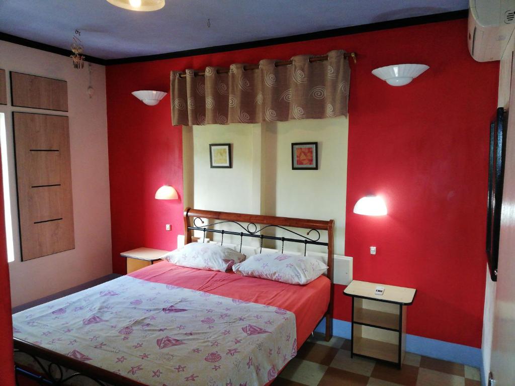 Rodrigues IslandVilla Acajou sur Mer的红色卧室设有红色墙壁的床