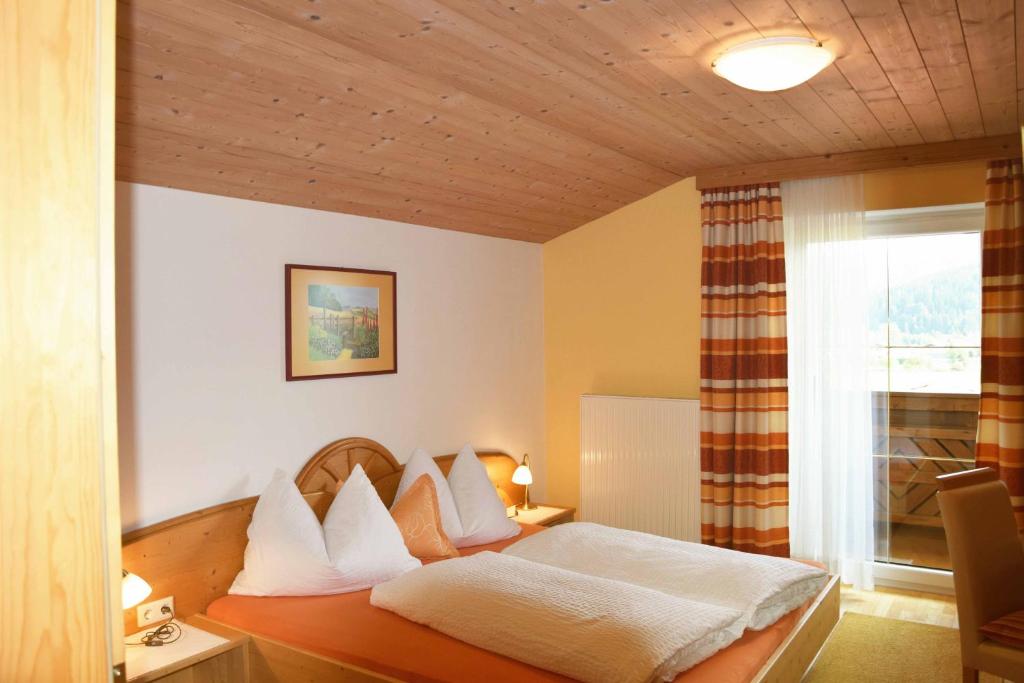 弗拉绍Ferienhaus Steger Maria的一间卧室配有一张带白色床单的床和一扇窗户。