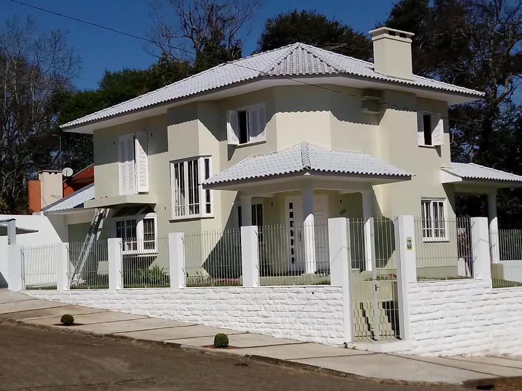 南圣克鲁斯CASA JE - Santa Cruz do Sul的白色的房子,有白色的围栏