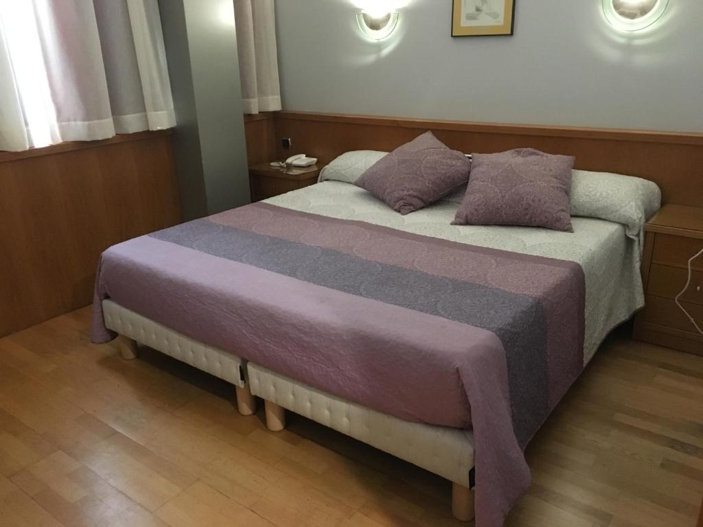 阿尔曼萨Encasa Hotel Almansa的一间卧室配有一张带两个枕头的床