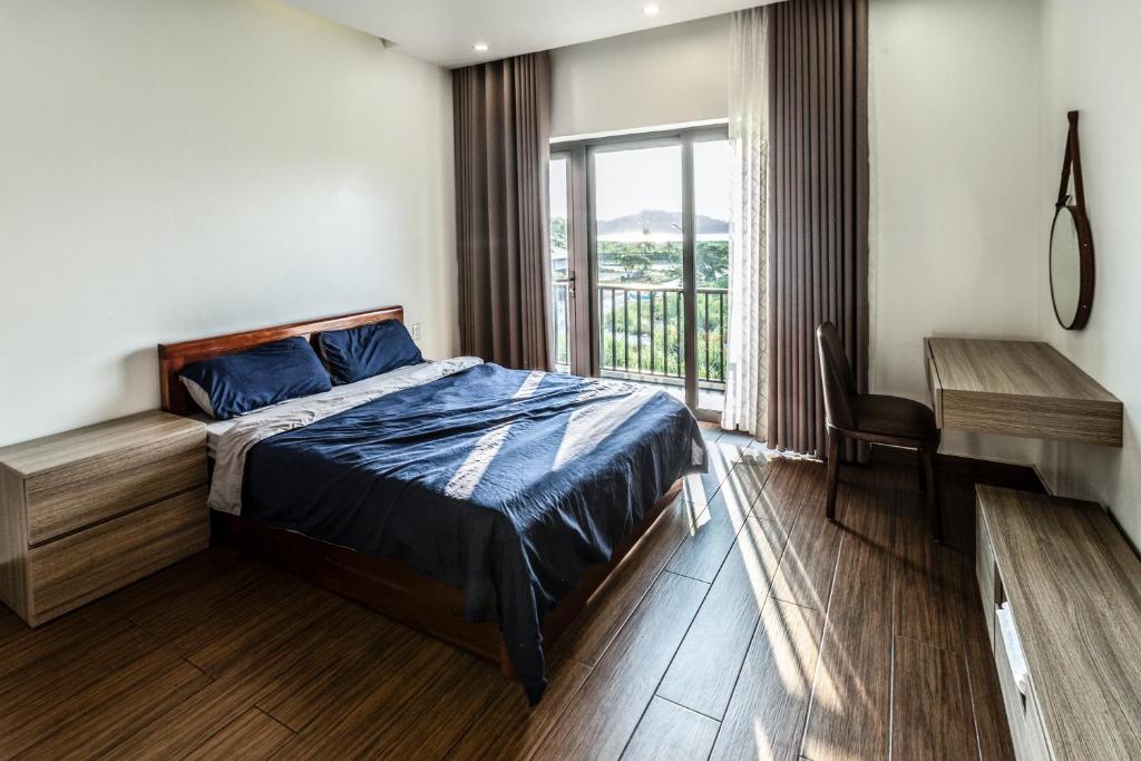 下龙湾Homestay Villa Full House的一间卧室配有一张床、一张书桌和一个窗户。