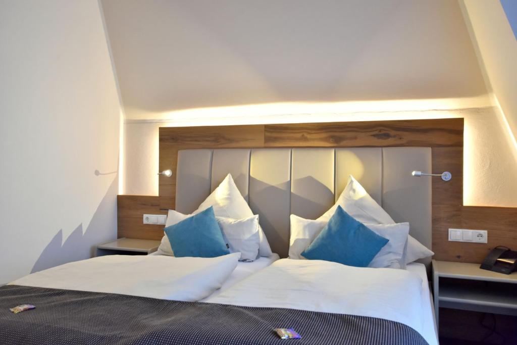 Kirchhatten德国之家酒店及餐厅的一间卧室配有一张带蓝白色枕头的大床
