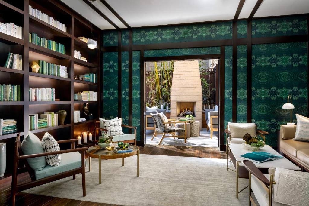 洛杉矶阿姆布罗斯酒店的客厅设有书架和壁炉
