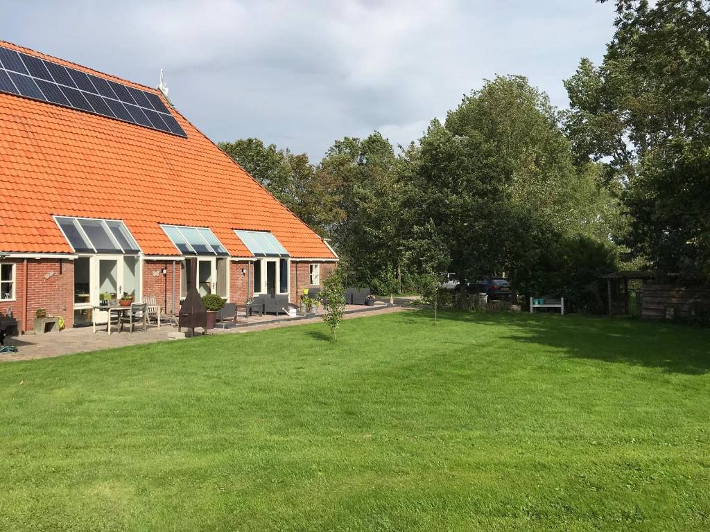 HempensAltenburgpleats的一座橙色屋顶房屋,上面装有太阳能电池板