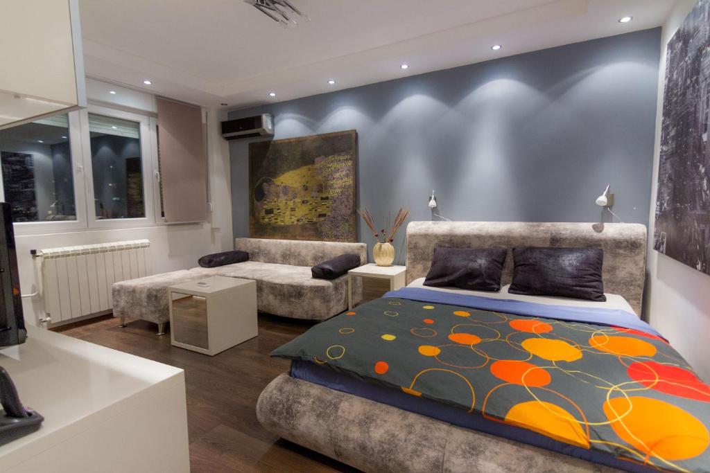 贝尔格莱德新城国际公寓式酒店的一间卧室配有一张床和一张沙发