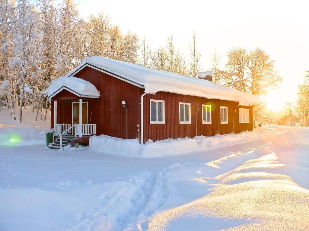 Laisvall斯道博恩斯图甘山林小屋的一座被雪覆盖的小建筑,后面是太阳