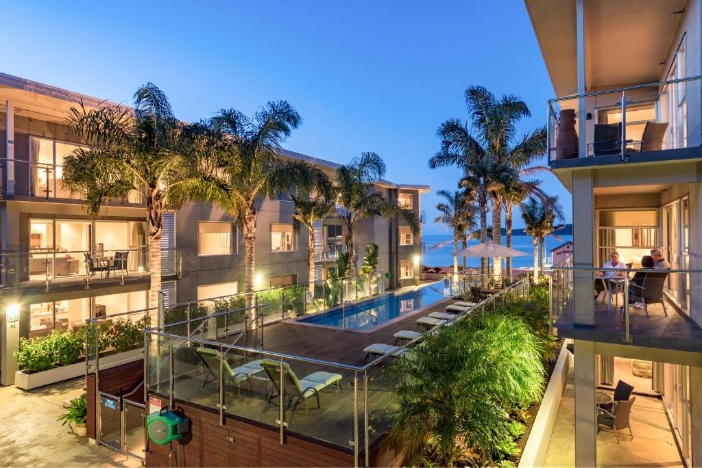 派西亚埃济沃特棕榈公寓式酒店的公寓大楼设有游泳池和棕榈树