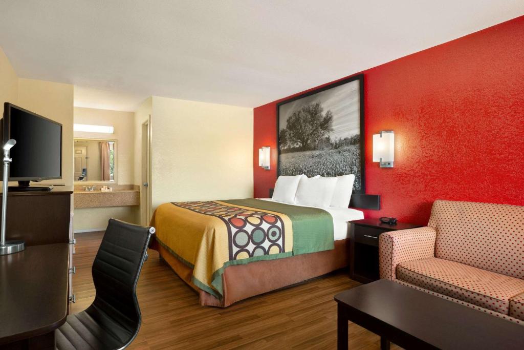 科西卡纳Super 8 by Wyndham Corsicana的酒店客房,配有床和电视