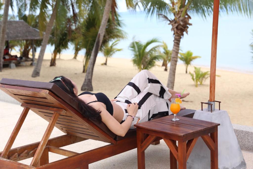 湄南海滩香格里拉哈简易别墅酒店的躺在沙滩上椅子上的女人