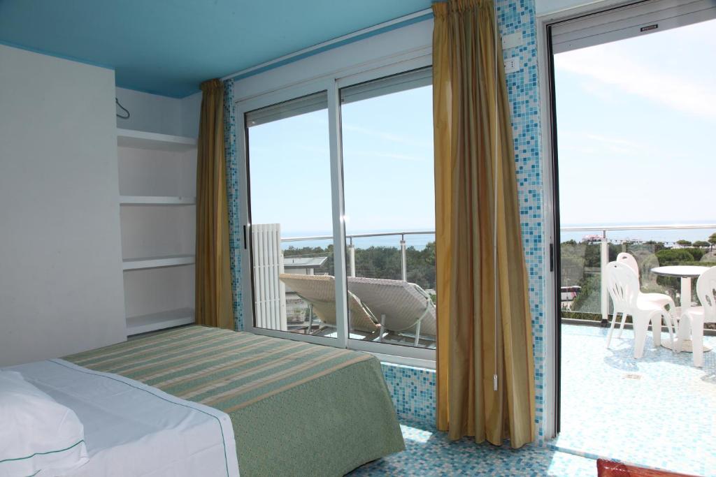 利尼亚诺萨比亚多罗索拉亚酒店的一间卧室设有一张床和一个美景阳台