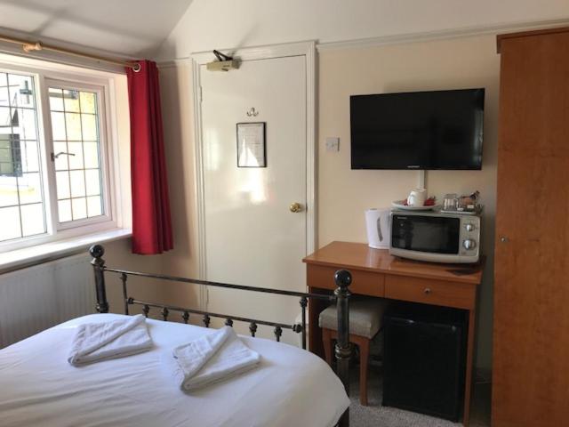 布拉克内尔阿德默勒旅馆的一间卧室配有一张床,书桌上设有微波炉