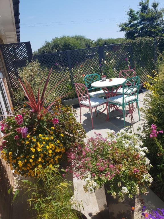 WoottonGoshens Farm B&B的庭院配有桌椅和鲜花
