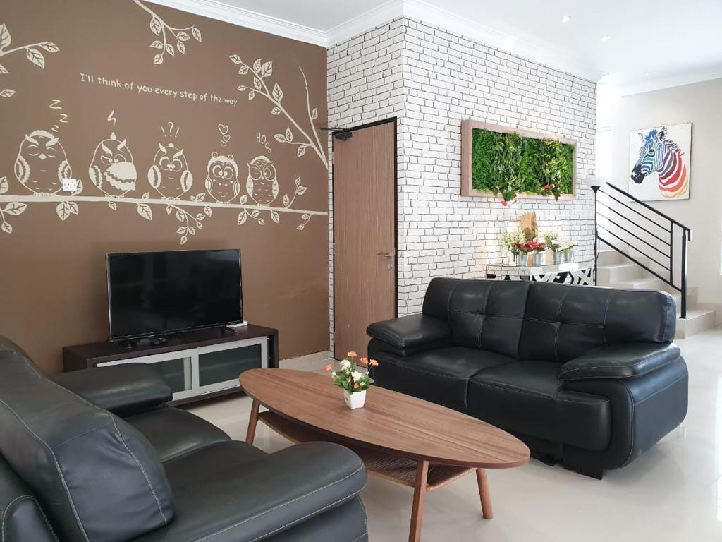 巴淡岛中心Danka@Taman Golf Residence的客厅配有沙发和桌子