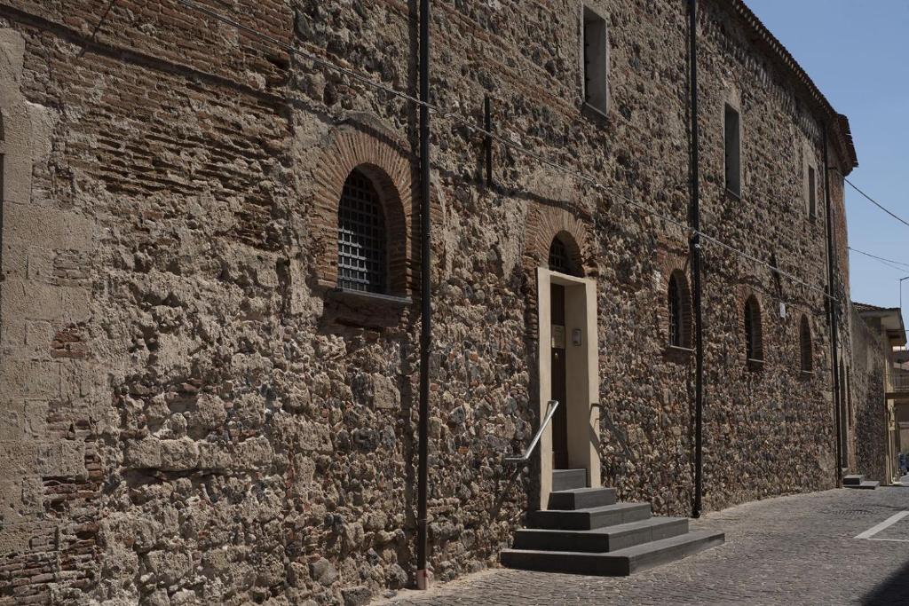 奥里斯塔诺Monastero Santa Chiara Guest House的砖砌建筑,楼梯通往门