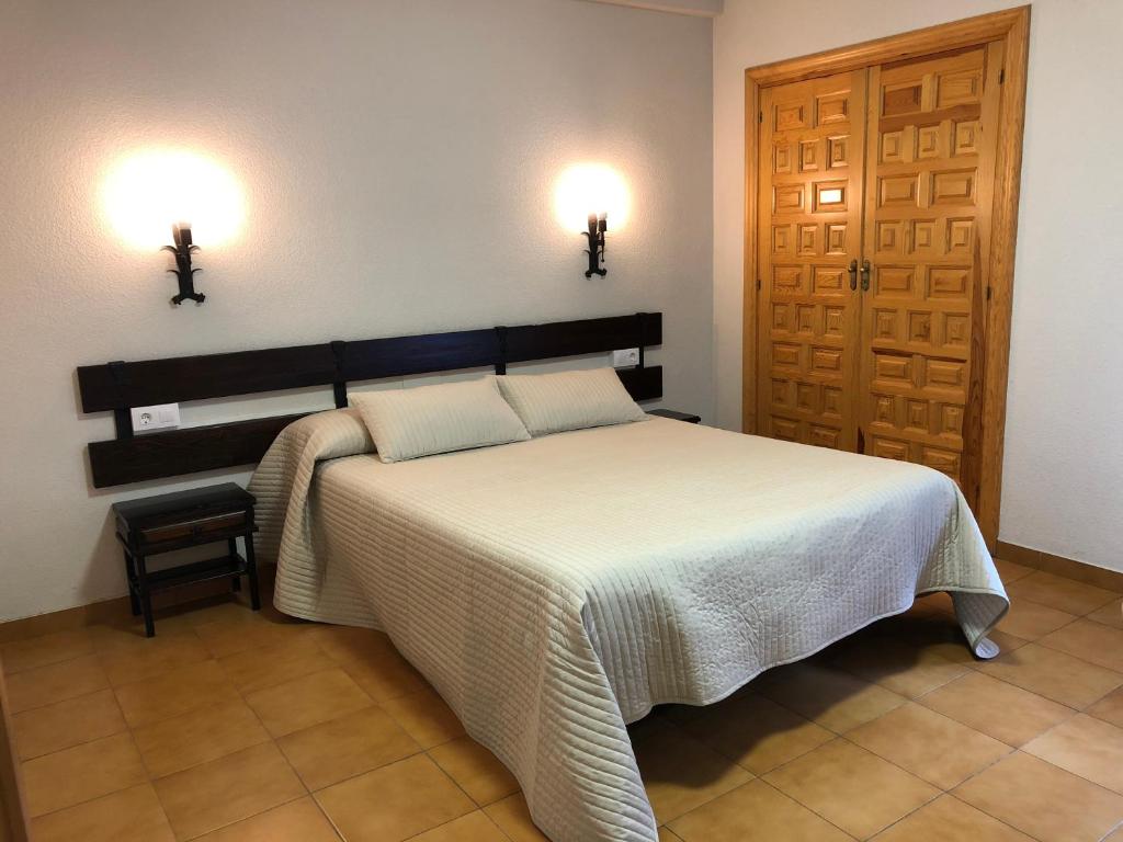 Viniegra de AbajoHotel La Venta de Goyo的卧室配有一张床,墙上有两盏灯