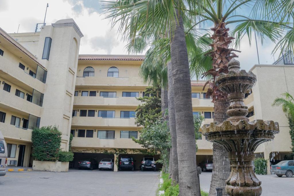 提华纳Hotel America的一座建筑前的棕榈树
