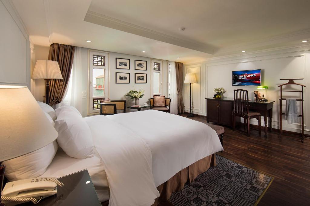 河内Hong Ngoc Dynastie Boutique Hotel & Spa的酒店客房设有一张白色大床和一张书桌