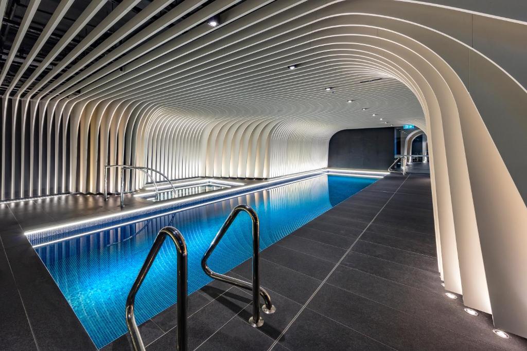 悉尼SKYE Suites Sydney的隧道内拥有蓝色灯光的游泳池