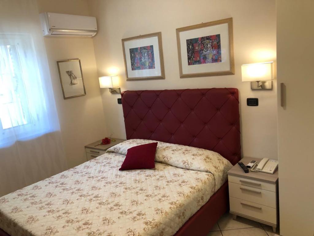 Soriano CalabroB&B Primerano SP73的一间卧室配有一张红色床头板的床