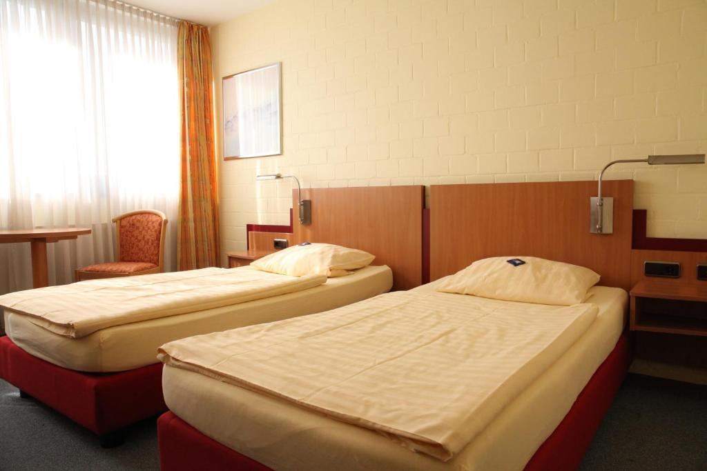 贝尔吉施格拉德巴赫RTB-Hotel - Sportschule的一间带两张床和椅子的房间