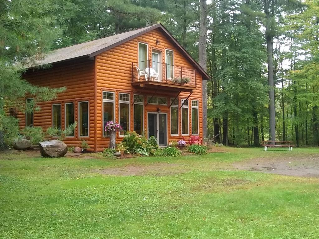 Pine CityBed and breakfast suite at the Wooded Retreat的树林中的小木屋 - 带阳台